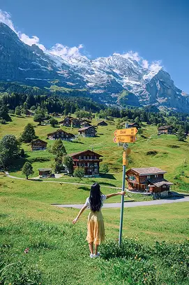A woman in a yellow skirt standing with a sign